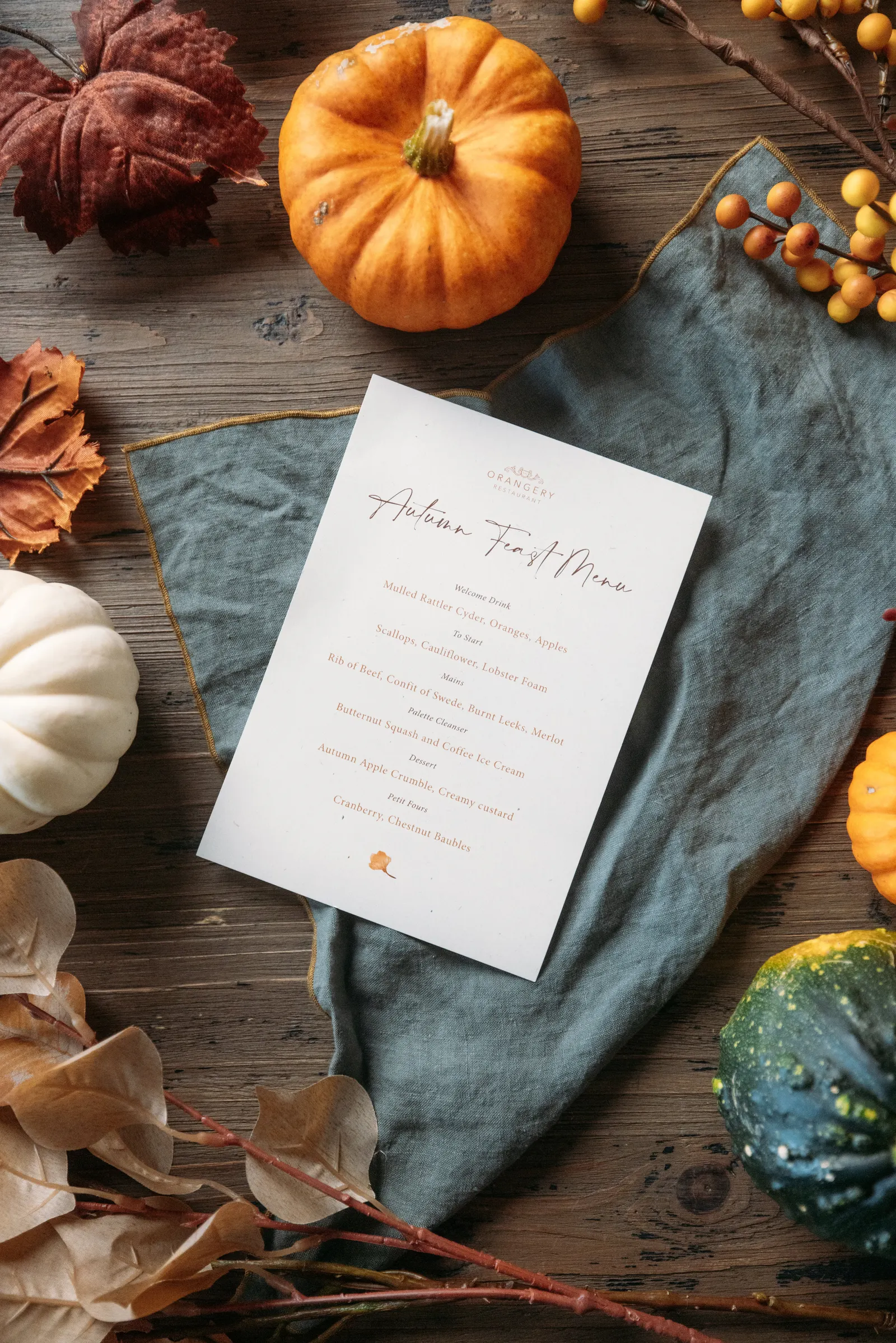 An autumn feast menu surrounded by pumpkins and seasonal foliage at Carbis Bay Estate