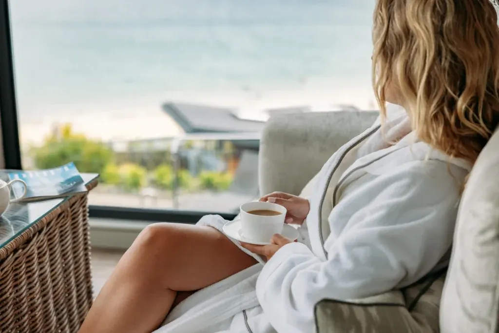 Guest enjoying tea and sea views at C Bay Spa
