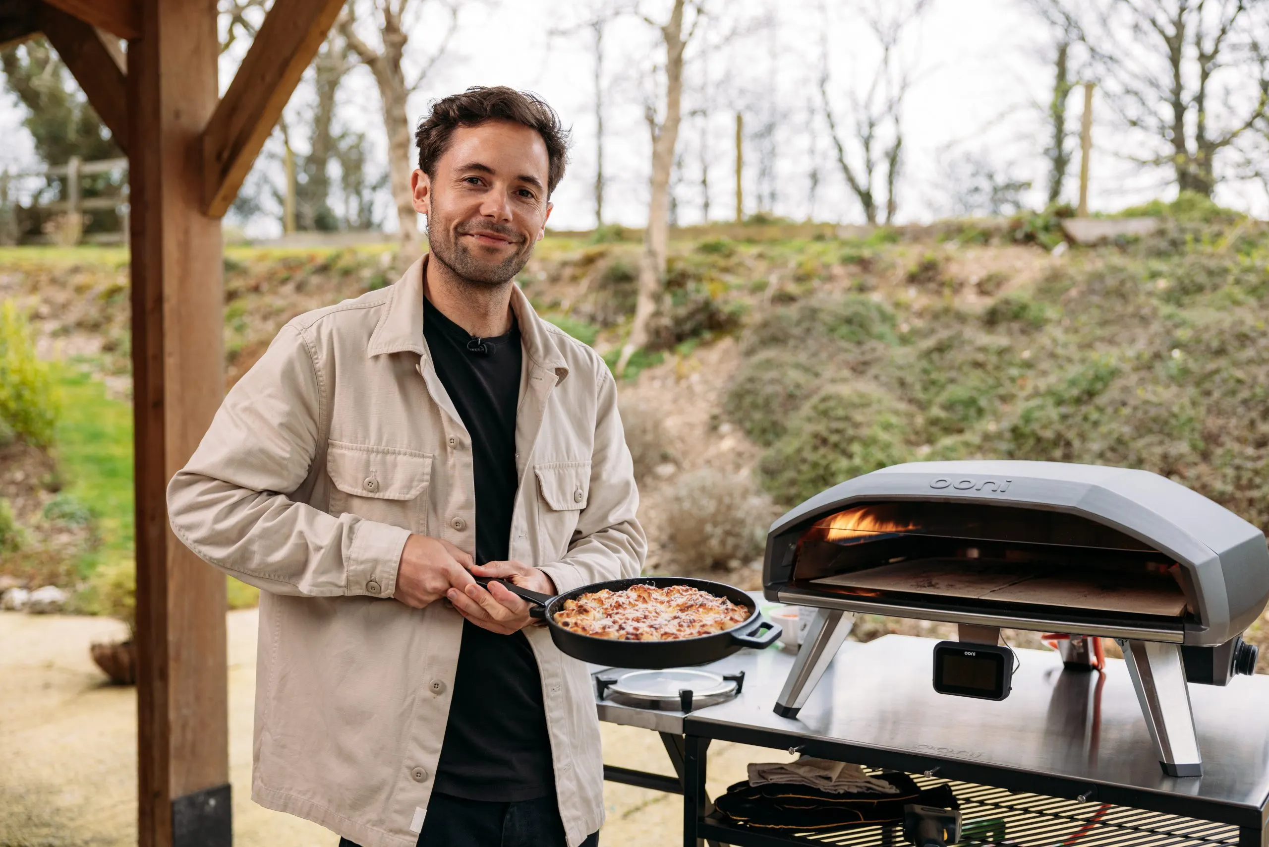 Grant Batty, Ooni ambassador and PixelRain filmmaker, holding garlic knots cooked in the Ooni Koda 2 Pro pizza oven