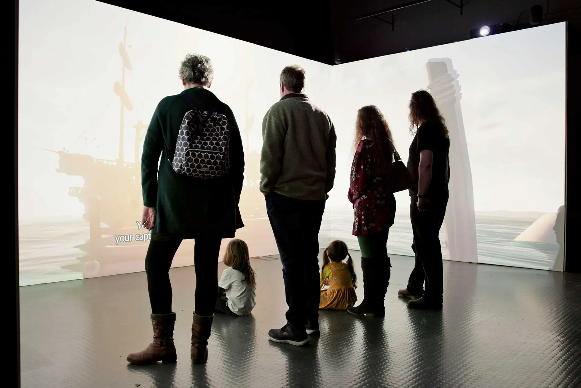 Visitors exploring the dark and atmospheric Pirates exhibition at National Maritime Museum Cornwall before it opened to the public