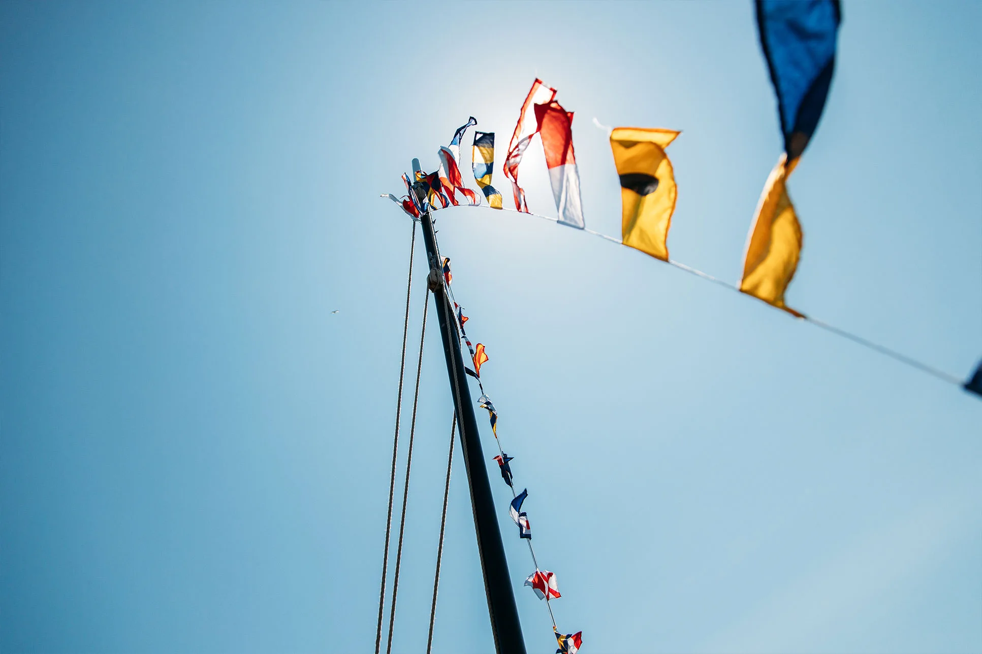 Maritime signal flags flying from Jonik’s mast, photographed during filming of the Heritage Boat Tours, Falmouth Harbour.